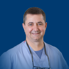 Dr. Paul Perry scrubs headshot blue background