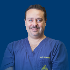 Dr. Timothy Hamby scrubs headshot blue background