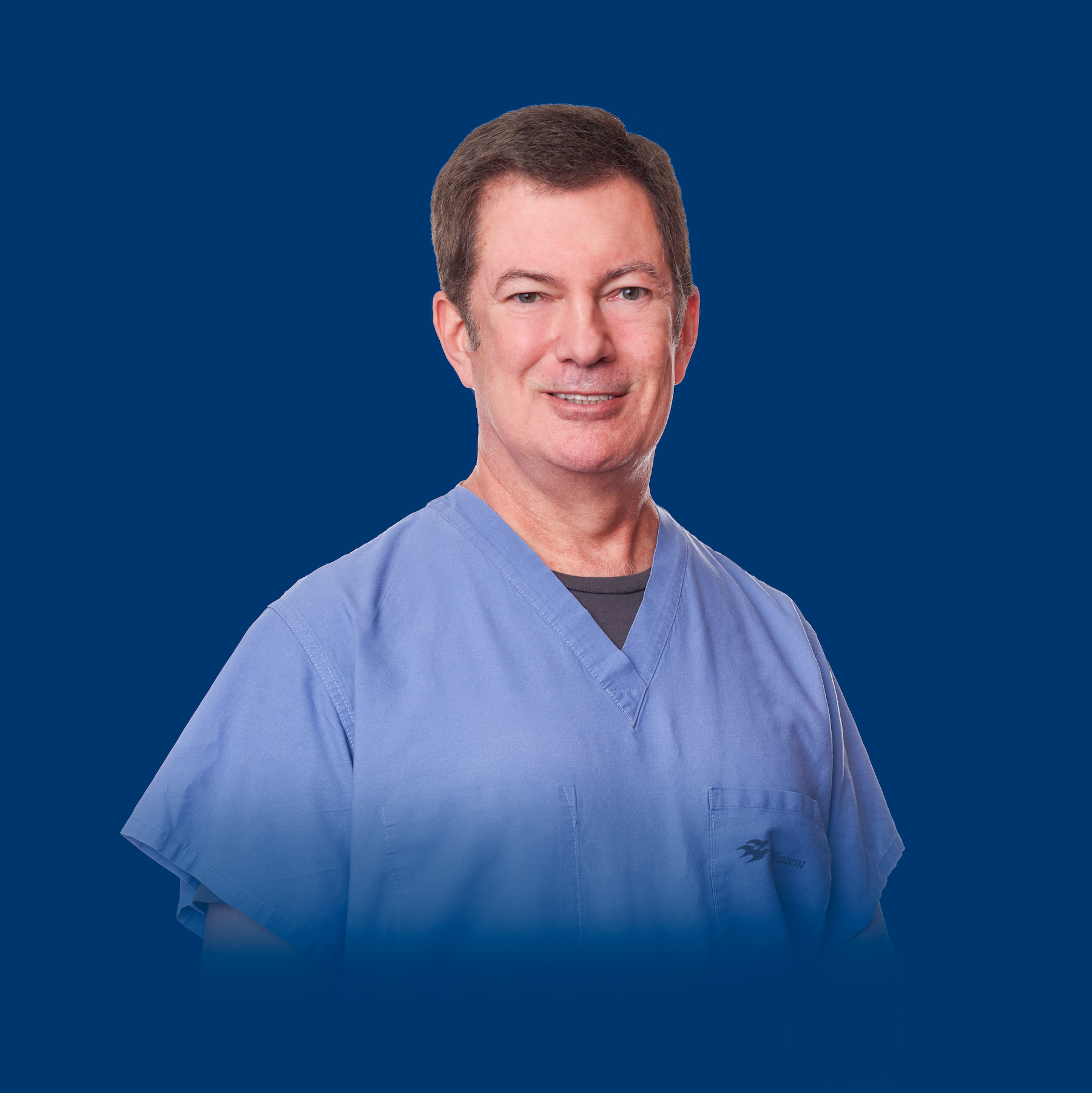 Dr. Christopher Sneed scrubs headshot blue background